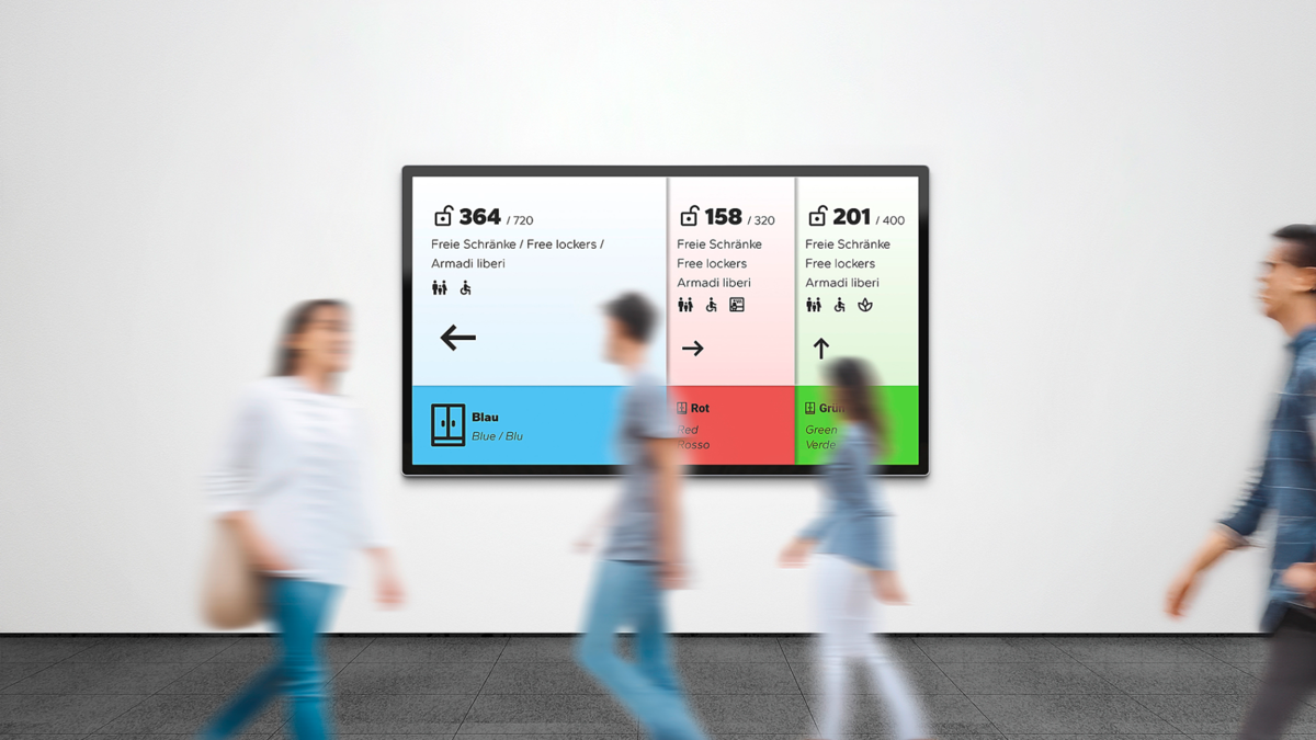 Current Lock Wireless Screendesign im Hintergrund, während Personen im Vordergrund daran vorbeilaufen.