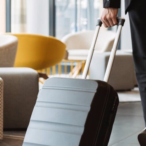 Person läuft mit Koffer durch eine Hotellobby