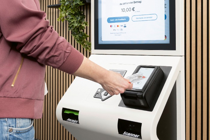 Person zahlt am Self Terminal per Kartenzahlung